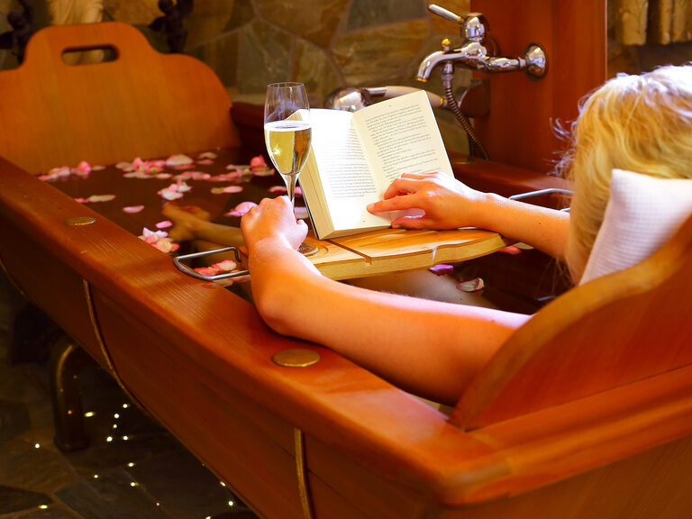 Frau im Bademantel sitzt in einer durchsichtigen Hängekugel im Hallenbad des 4 Sterne Erwachsenenhotel Hüttenhof in Niederbayern Frau im Bademantel sitzt in einer Hängekugel im Hallenbad des 4 Sterne Luxushotel Hüttenhof im Bayerischen Wald